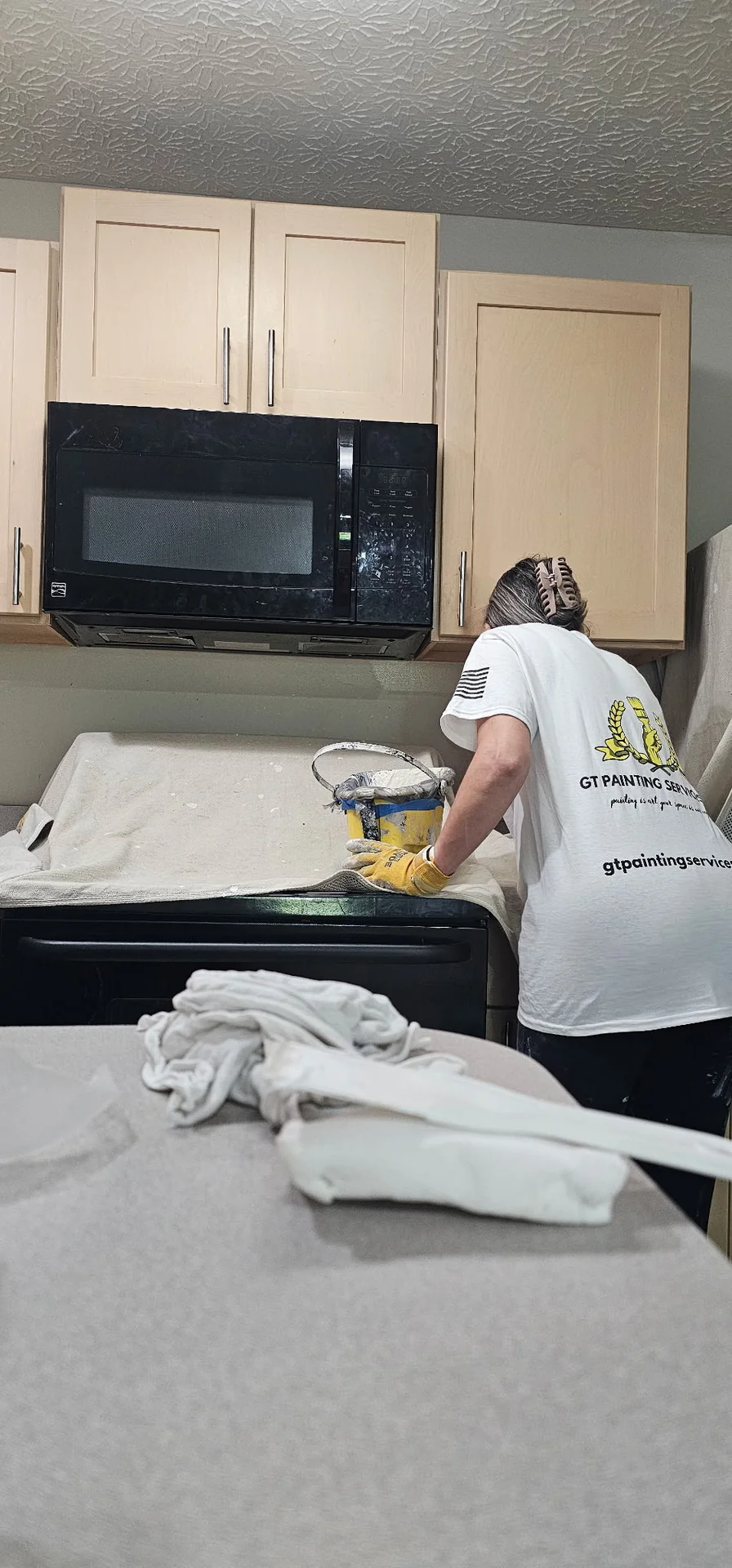 GT Painting Services crew member prepping and painting an apartment kitchen